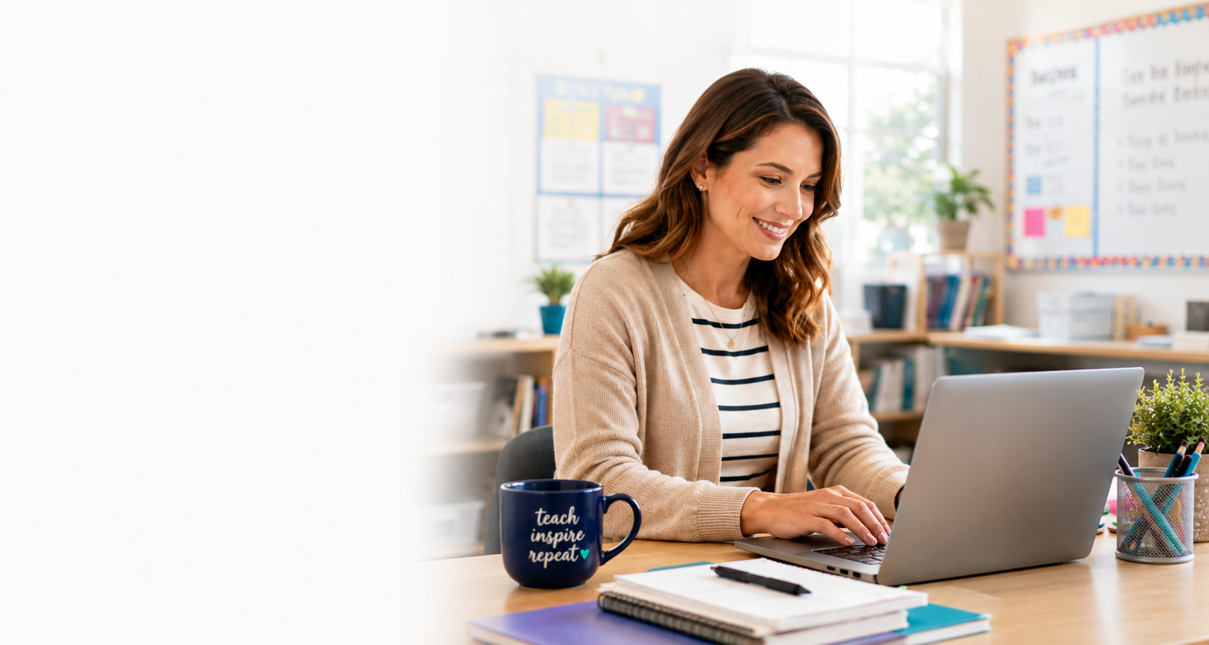 A teacher planning lessons at her laptop in a bright, welcoming classroom
